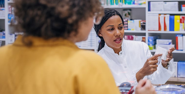 Pharmacist showing customer immunosuppressants for eczema