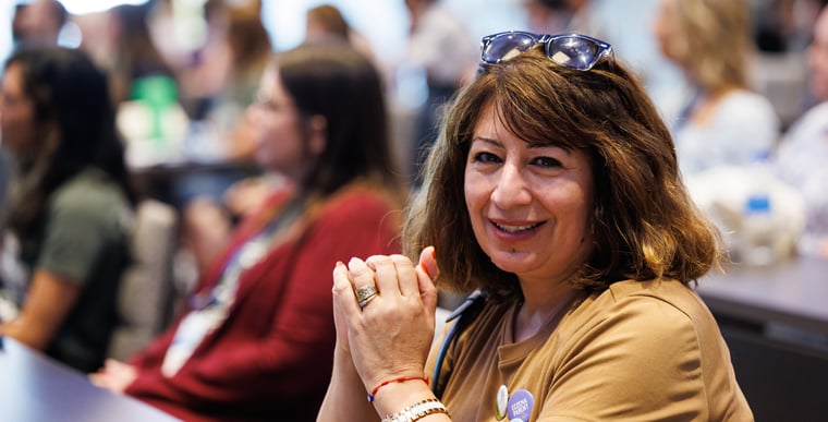 Woman smiling at camera for picture in crowd