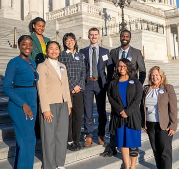 Group posing on steps outside building