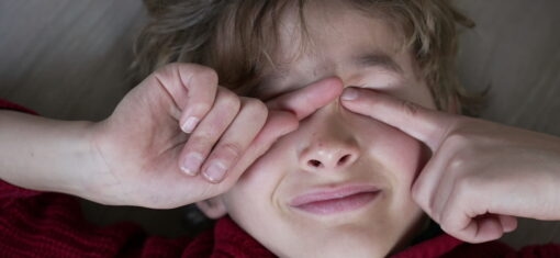 Child rubbing their eyes, illustrating eye irritation and discomfort associated with eczema and eye health issues.