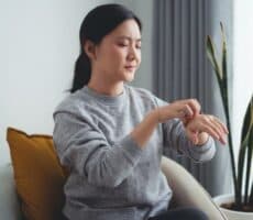 a woman scratches her hand
