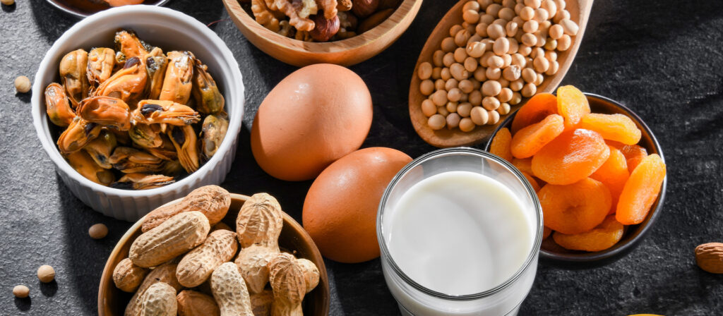 Eggs, nuts, dried fruits, milk and other foods artfully placed on a black background