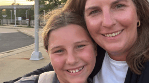 Amy and her tween daughter, Ella, smile toward the camera in a selfie-style photo