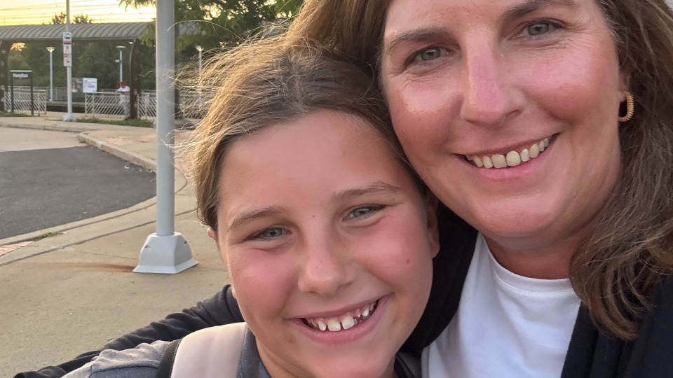 Amy and her tween daughter, Ella, smile toward the camera in a selfie-style photo