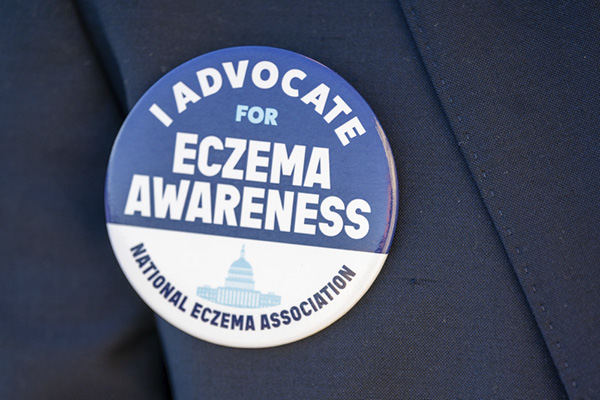 Lapel pin with the text "I advocate for eczema awareness – National Eczema Association."
