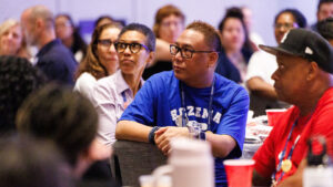 Ed Taguba sitting amongst a crowd and listening to a talk at Expo 2025