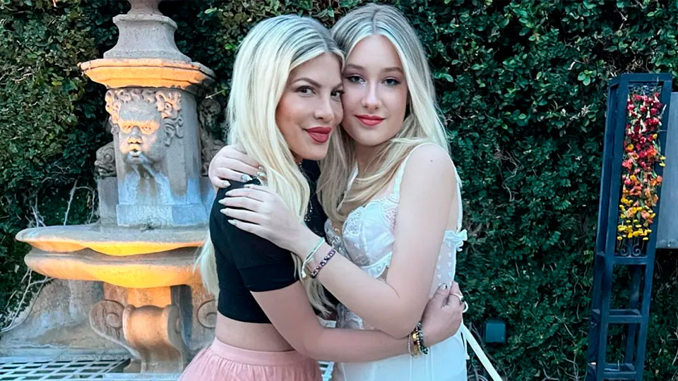 Tori Spelling and her daughter, Stella, hug and smile at the camera.